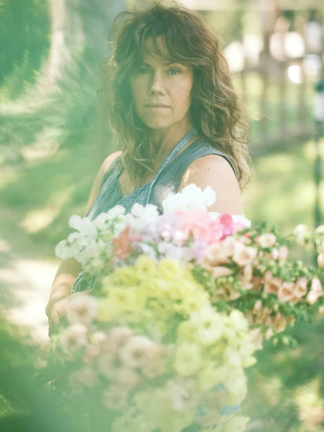 Una donna tiene un mazzo di fiori dai colori tenui